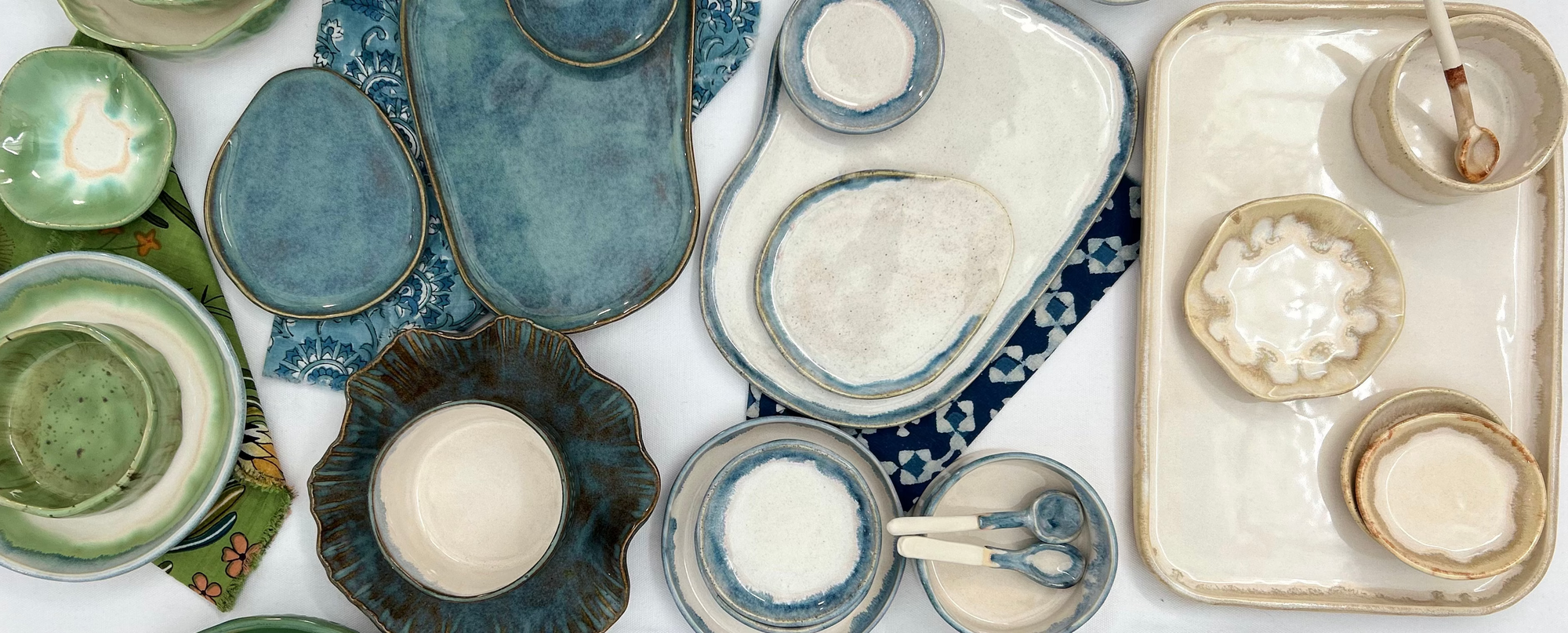 Collection of ceramic dishes in various shapes and colors on a white background